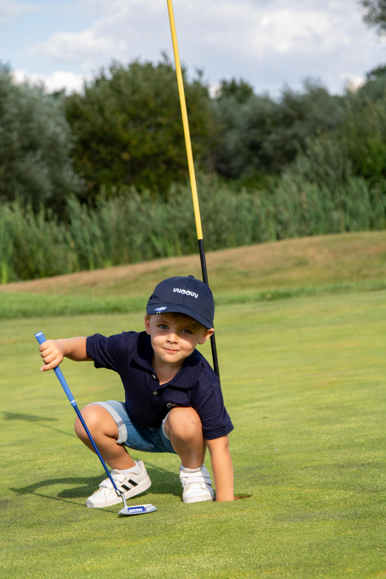 Ein kleines Kind, das einen Putt mit einem WOOW Putter vorbereitet